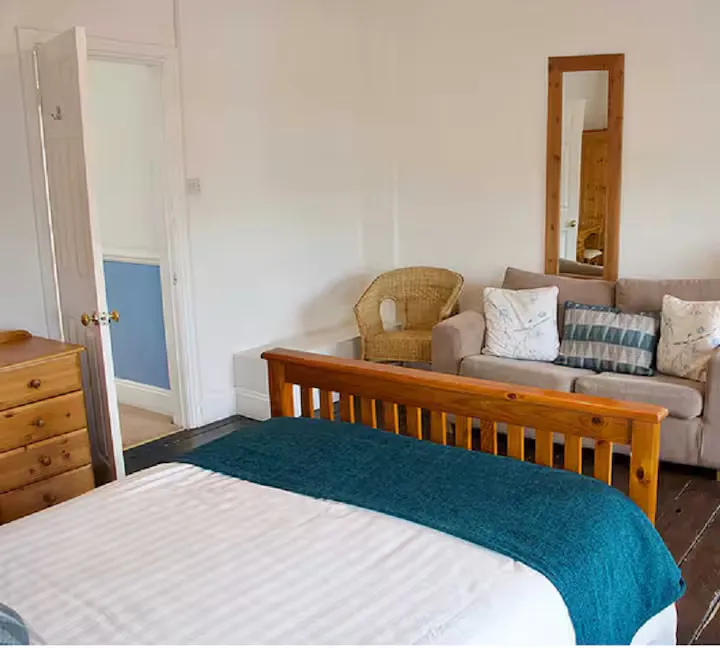 A spacious bedroom with a double bed and an additional sofa