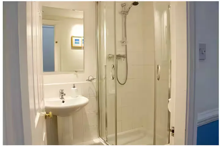 A shower room with a glass walk-in shower and pedestal basin